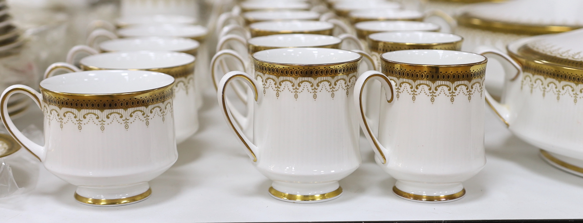 A Paragon Athena pattern blue and gilt tea service including three lidded tureens, oval platter and dinner plates, the largest 38cm wide